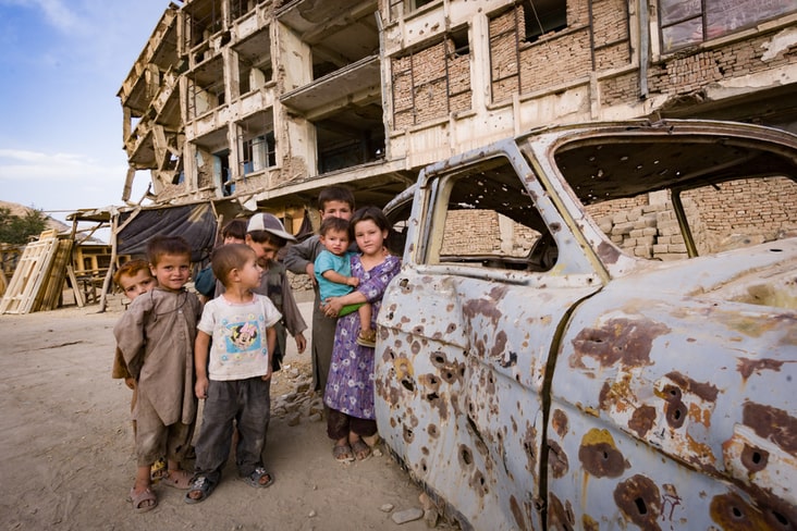 A destroyed car and children in Kabul