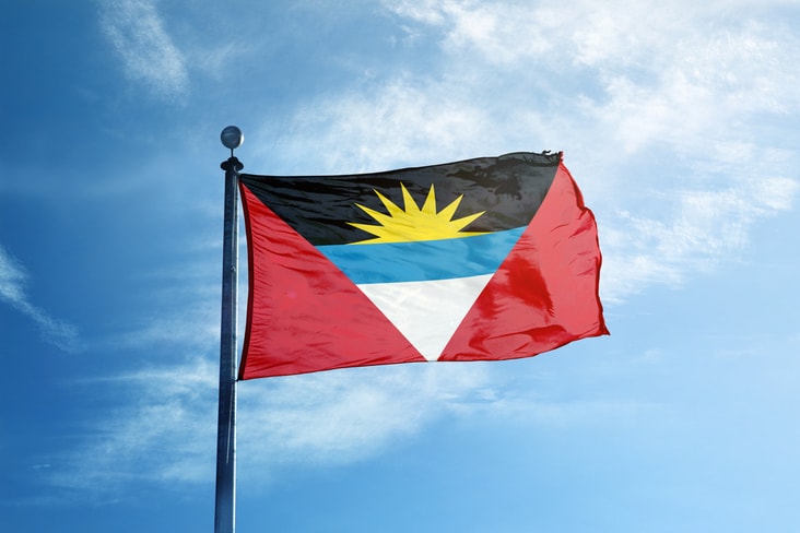 The Antigua and Barbuda flag flying against blue skies