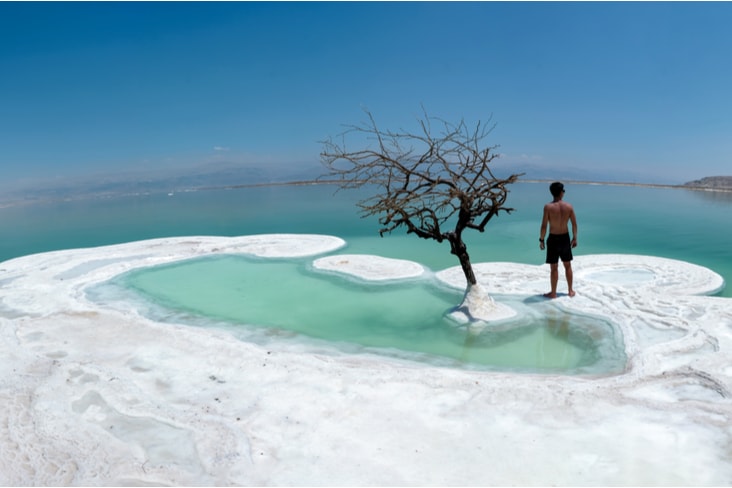 Man stands on salt in the Dead Sea