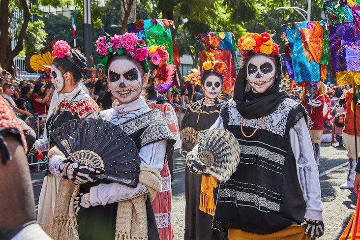 People dressed up and wearing masks during Día de Muertos celebrations