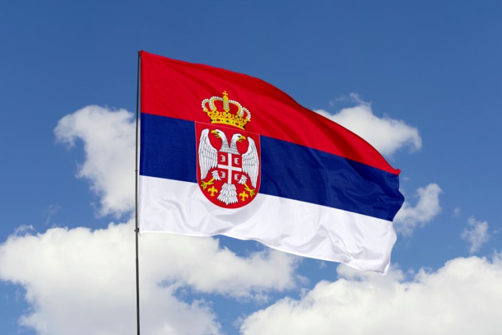 Serbia's flag flying against a blue sky