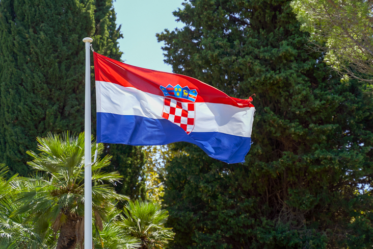 Croatia's flag flying near tress 
