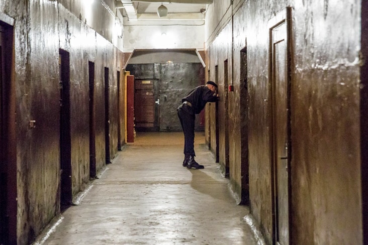 A guard patrols a corridor in the prison 