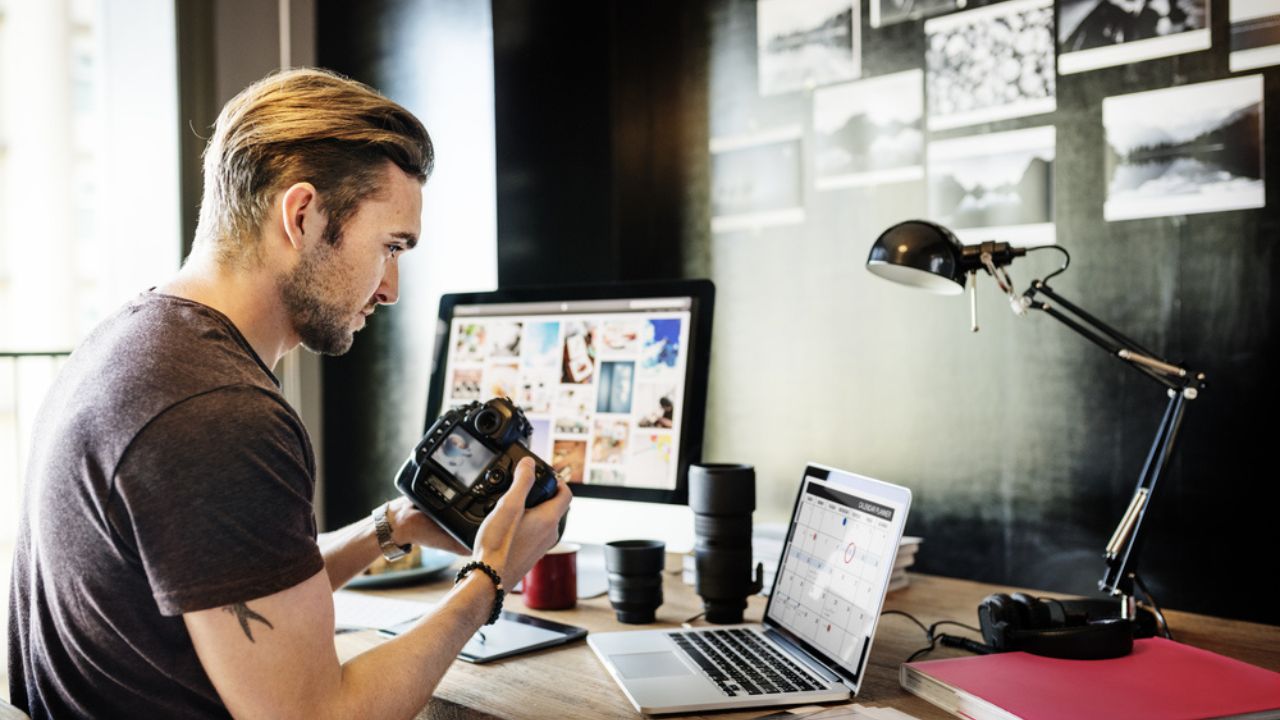 Photographer with-digital camera and laptop.